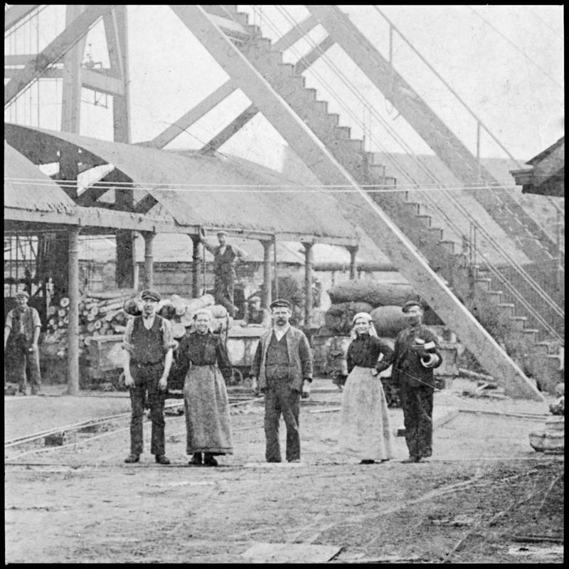 Black and white film negative of a photograph showing men and women near pit top, Whitworth Colliery.  &#039;Whitworth&#039; is transcribed from original negative bag.