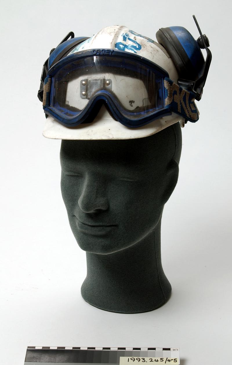 White plastic miner&#039;s helmet with attached ear defenders