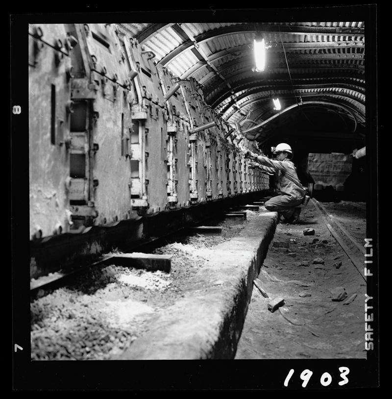 Black and white film negative showing an electrician inspecting electrical panels? Oakdale Colliery, May 1980.  &#039;Oakdale May 1980&#039; is transcribed from original negative bag.