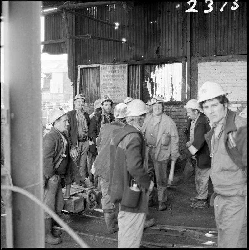 Black and white film negative showing a group of miners on the surface, Morlais Colliery 13 May 1981.  &#039;Morlais 13/5/81&#039; is transcribed from original negative bag.