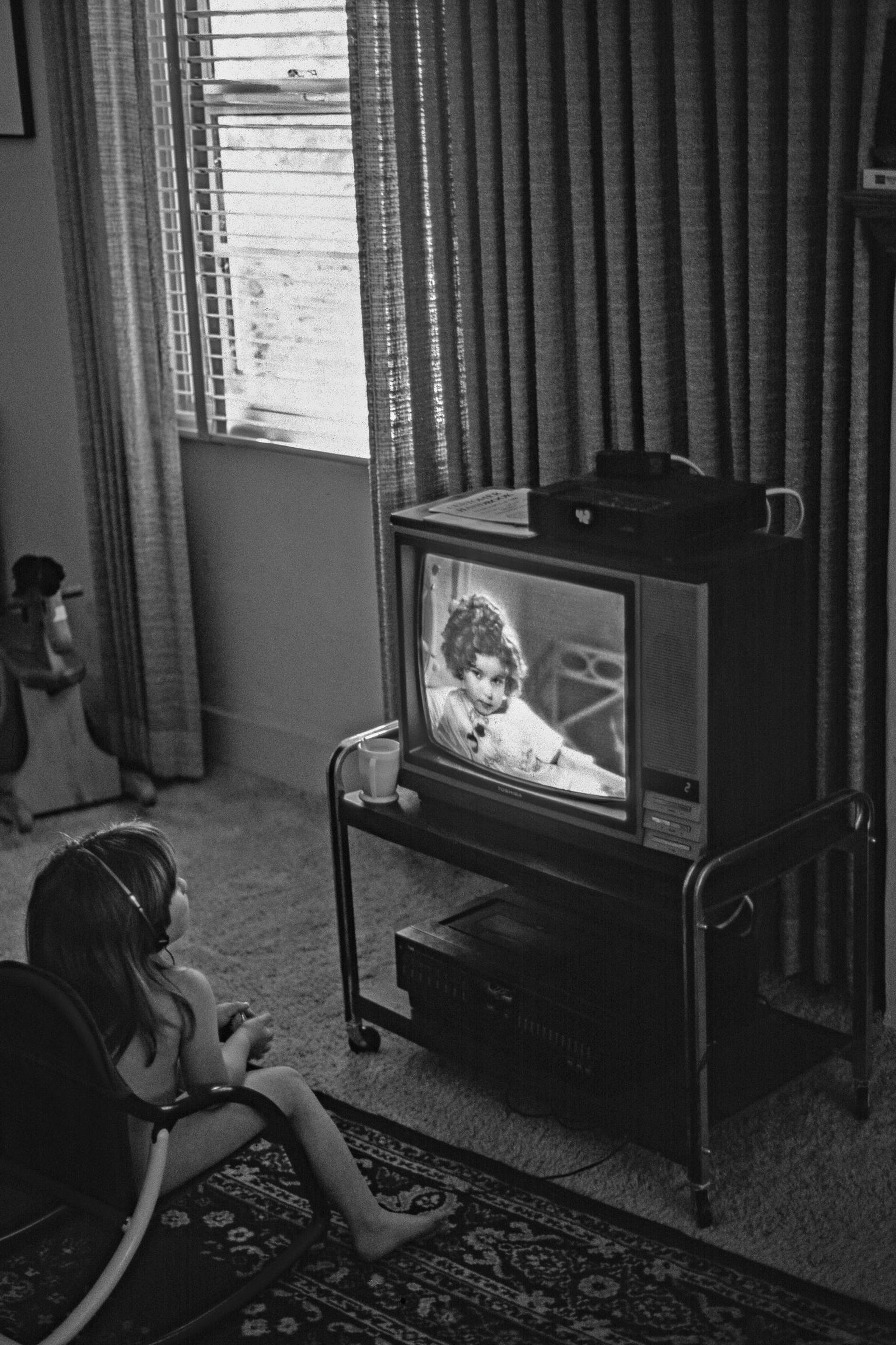 Child watching old film of Shirley Temple. Tempe, Arizona USA