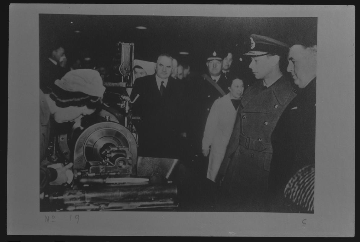 Film negative of a photograph showing visit of King George VI and Queen Elizabeth to Currans, Butetown during World War II. King talking to a member of staff.