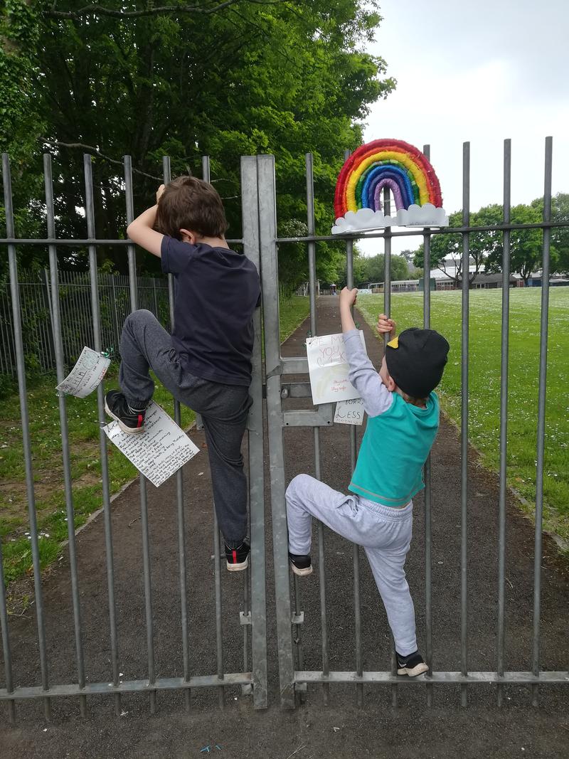 Children climbing gates of school.