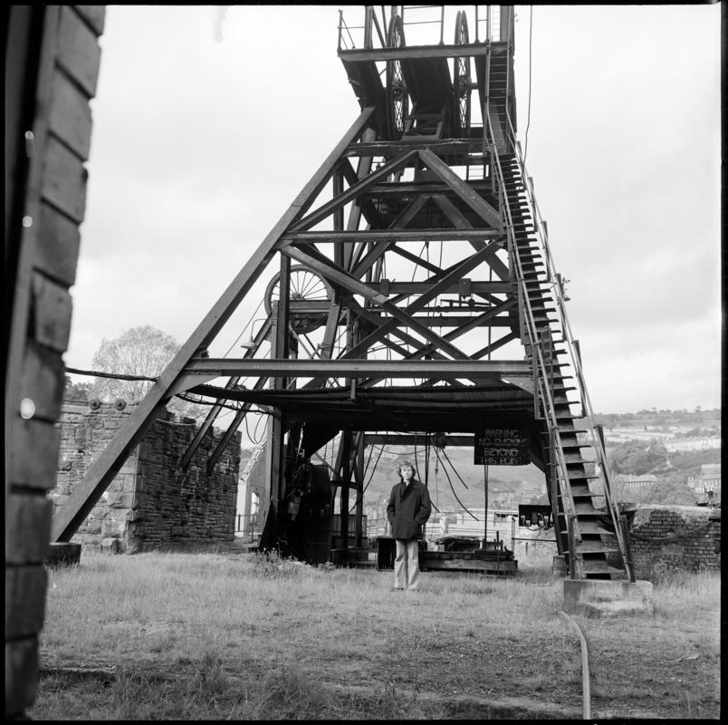 Black and white film negative showing a man stood at the base of the headframe,  Llanhilleth Colliery.  &#039;Llanhilleth&#039; is transcribed from original negative bag.