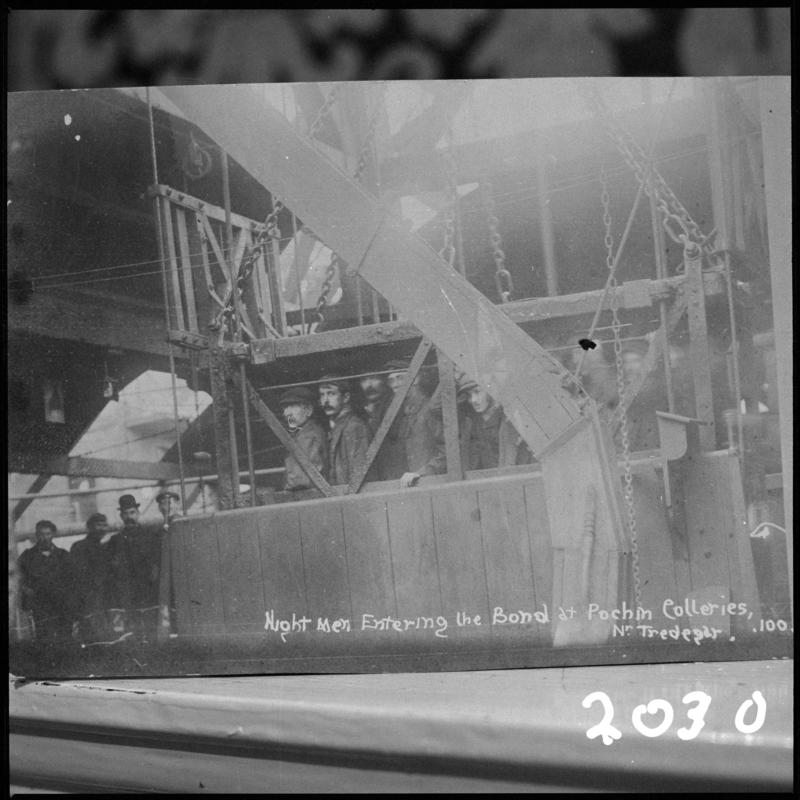 Black and white film negative of a photograph showing the &#039;night shift entering the bond at Pochin Colliery, Tredegar&#039;.  &#039;Pochin&#039; is transcribed from original negative bag.