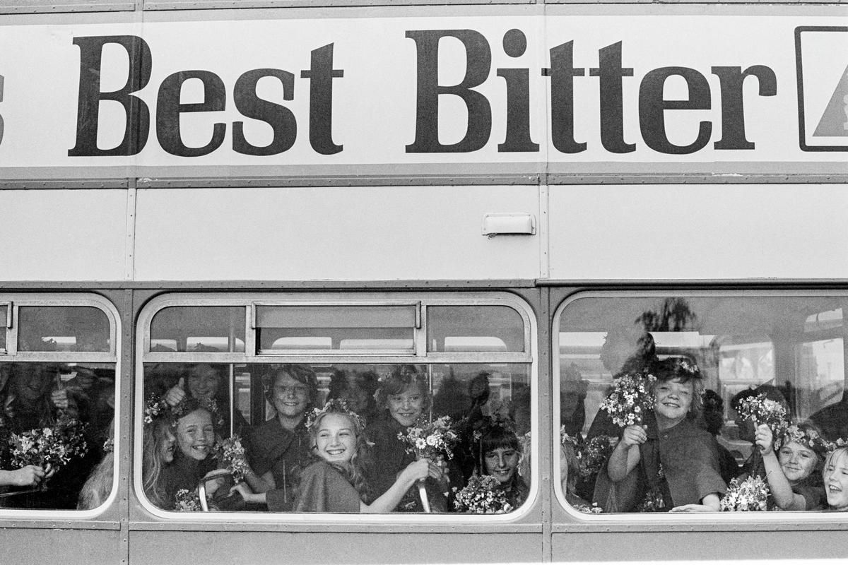 GB. WALES. Wrexham. National Eisteddfod. Flower girls arrive by coach. 1977.