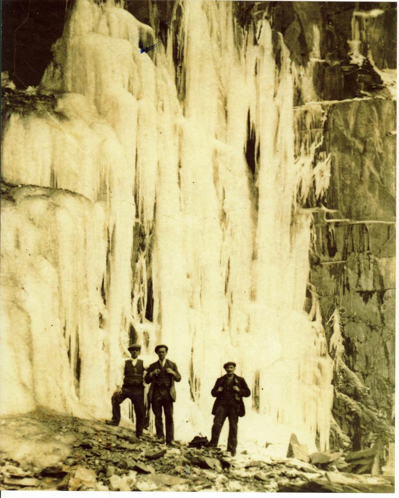 Dick Cae Glas (on left) and two gentlemen standing in front of a sheet of ice, Dinorwig Quarry