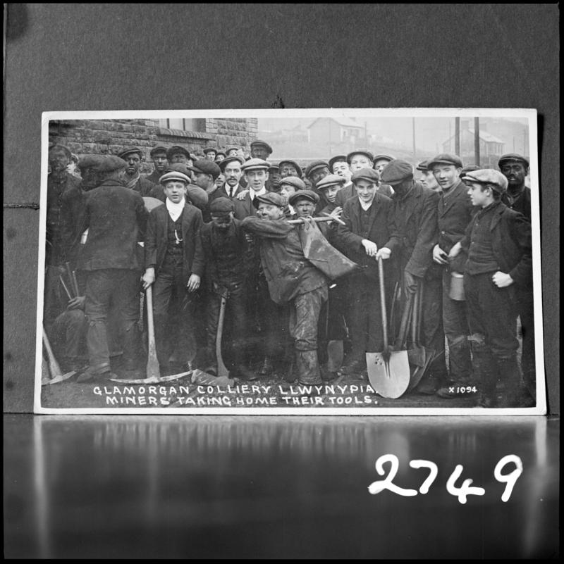 Black and white film negative of a photograph showing a group of miners at Glamorgan Colliery.  &#039;Men at Glamorgan Colliery taking home tools&#039; is transcribed from original negative bag.
