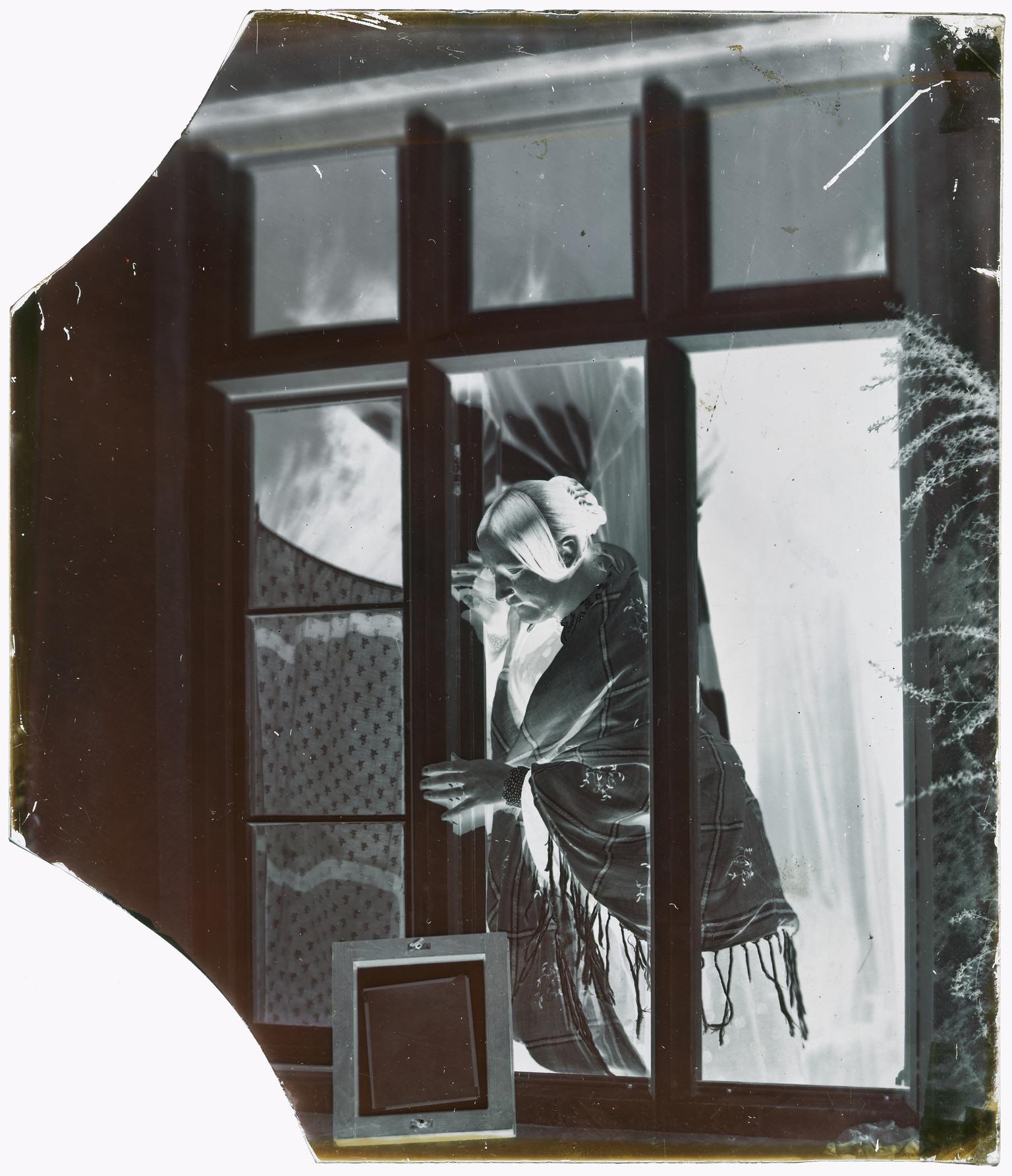 Emma making a photographic print, glass negative