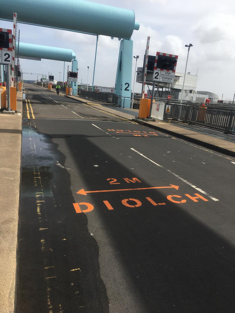 2m social distancing signage painted on the road over the Cardiff Bay Barrage. Photo taken the day the painting was being undertaken.