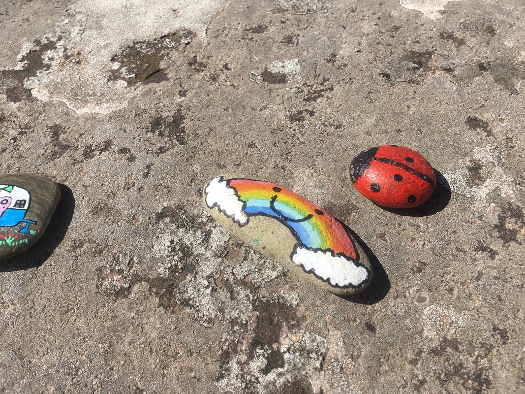 A pebble depicting a rainbow and a pebble depicting a ladybird on Boughrood Bridge, over the River Wye, Boughrood, Powys.
