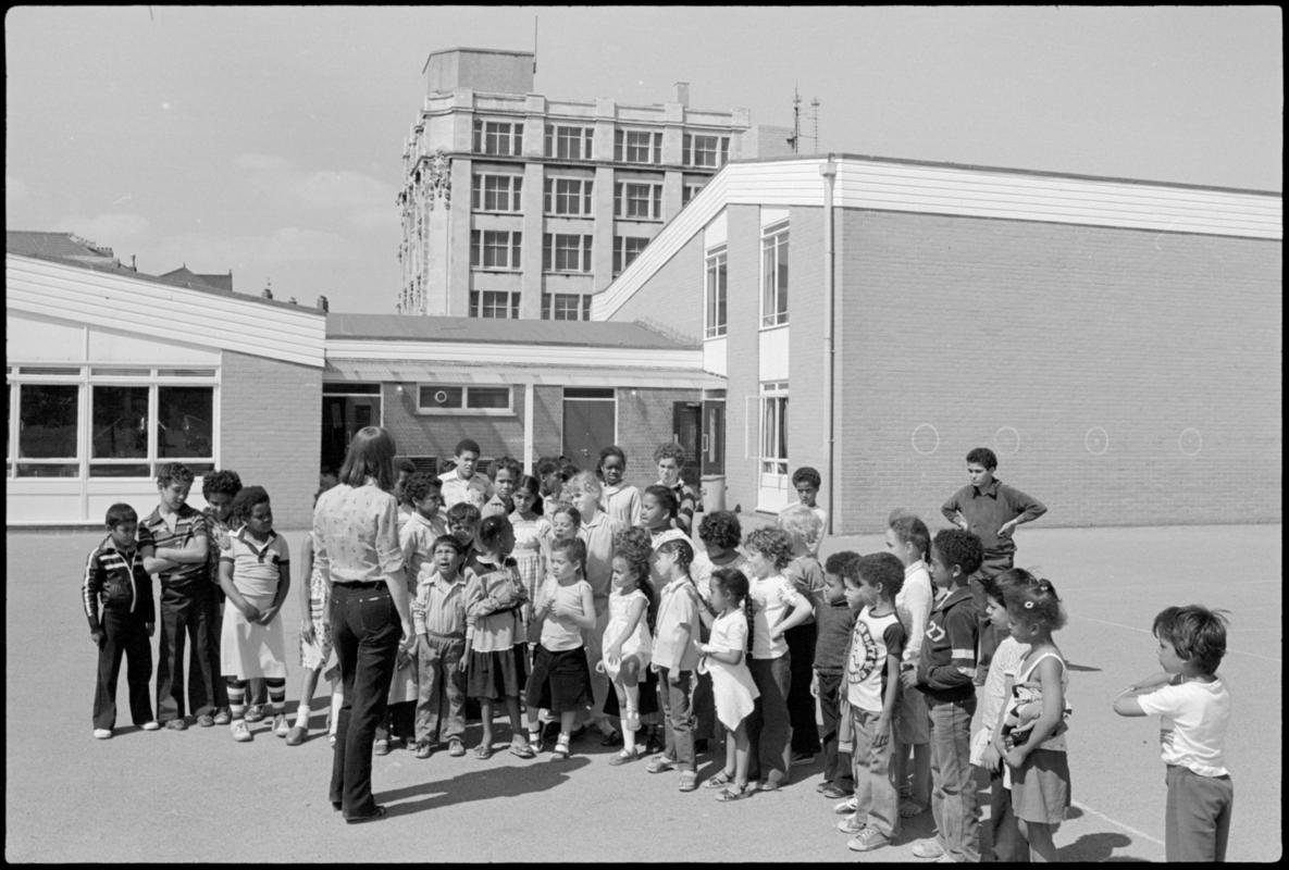 Group of children and teacher Mrs Davies in the playground at Mountstuart Primary School, Adelaide Street, Butetown.
