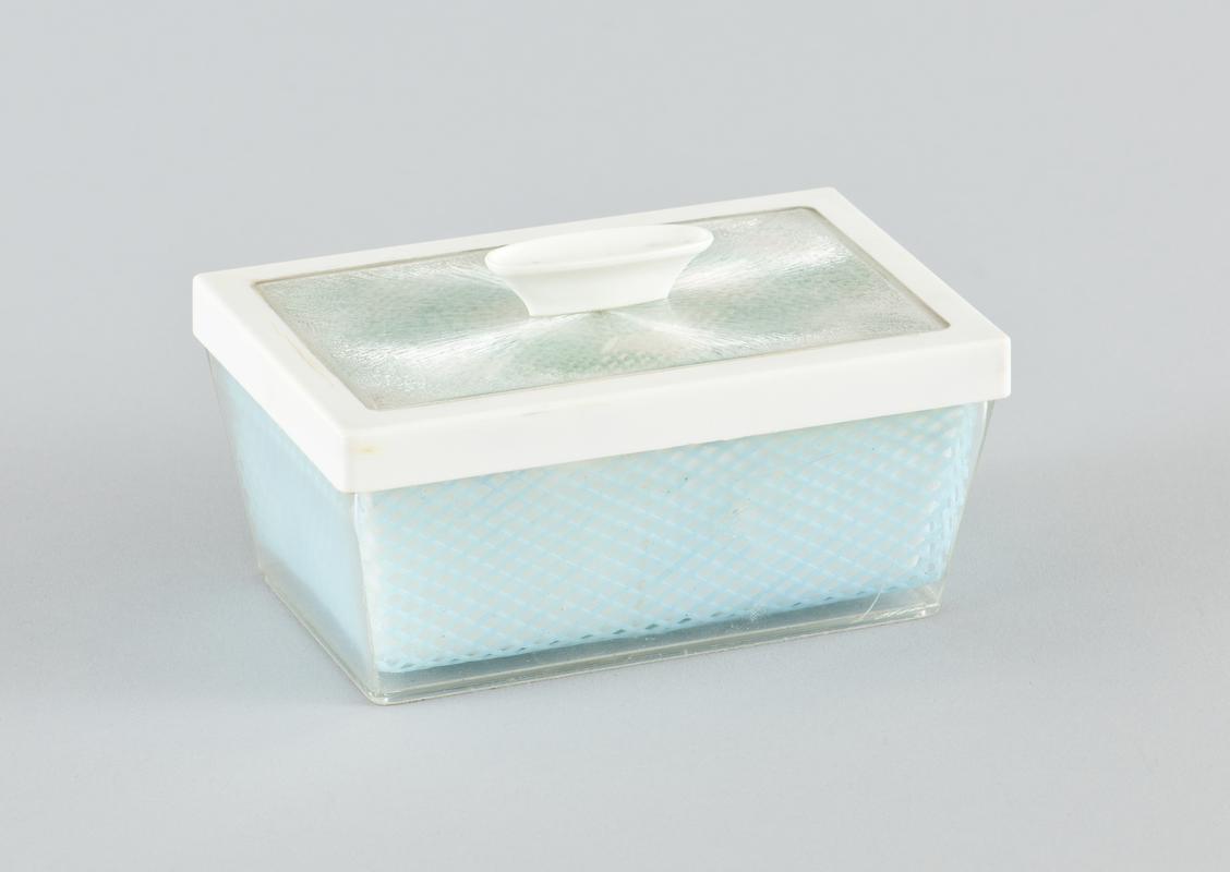 Plastic butter dish with removable lid. base of dish comprises white plastic reovable butter tray, blue plastic &#039;trellis&#039; decorative sheet and these sit within clear plastic outer base. Top has blue and white checked material seen through clear plastic outer casing.