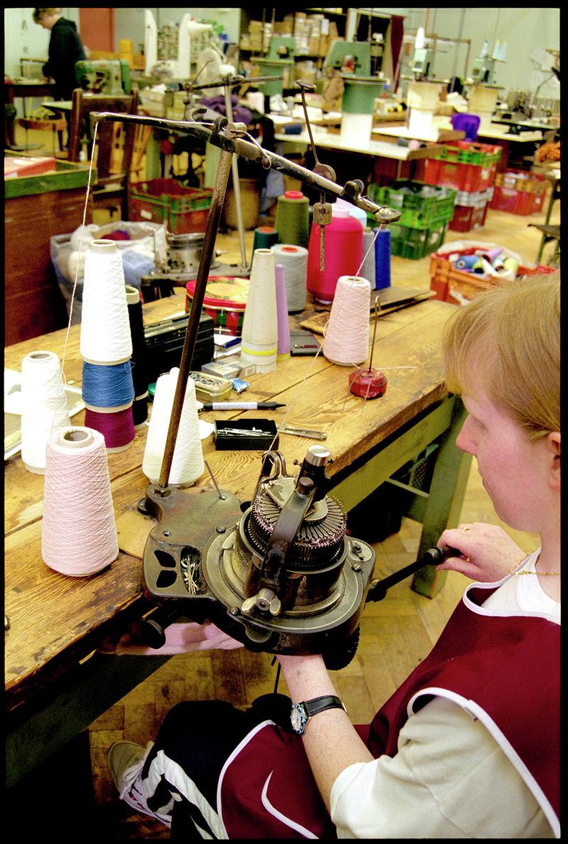 Andrea Rockman turning a handle to operate a sock kniting machine. Corgi Hosiery Ltd factory, Ammanford, 1 July 2002.