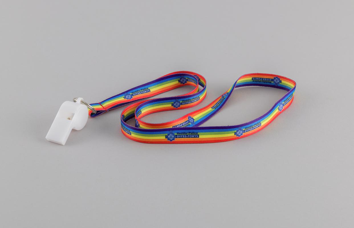 White plastic whistle on Pride Rainbow Dyfed-Powys Police lanyard.