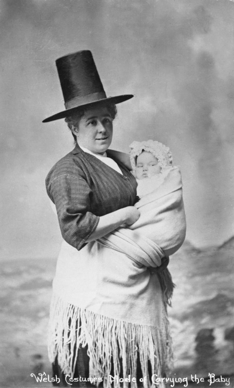 Lady in traditional Welsh costume carrying baby in shawl