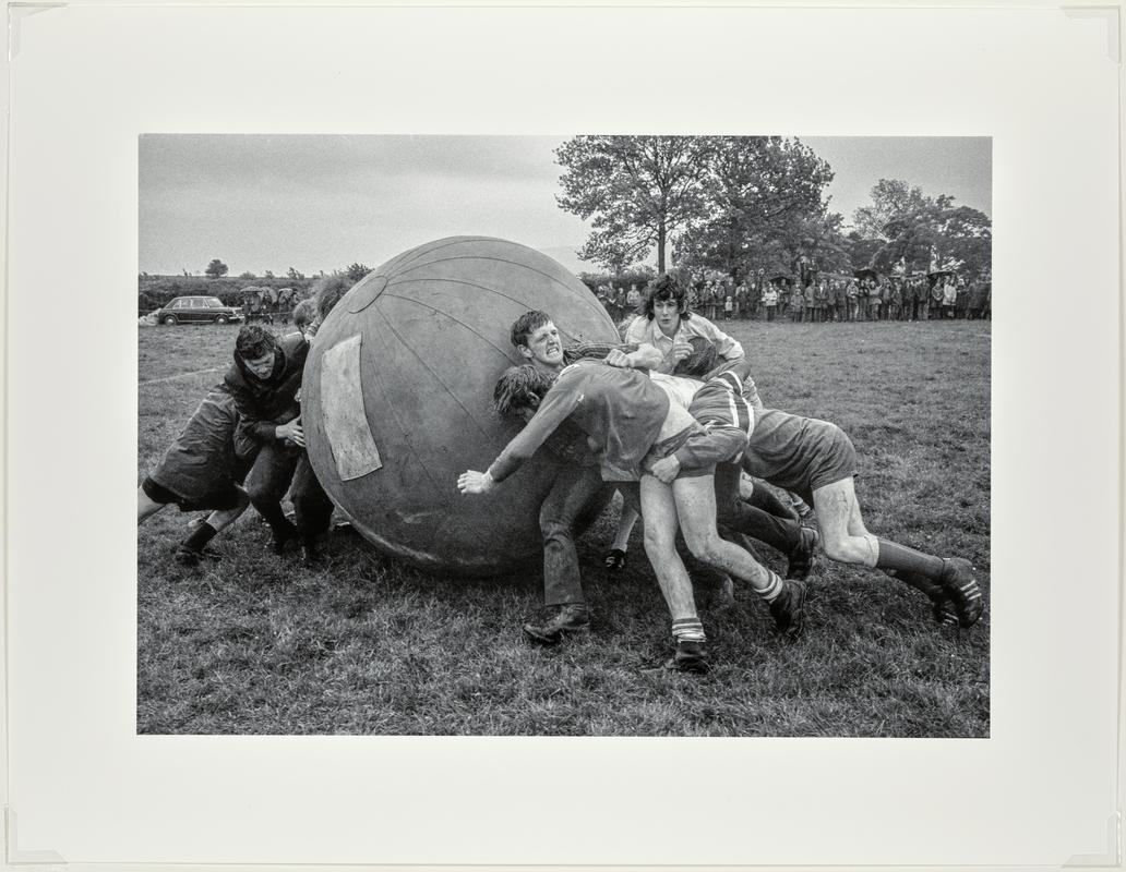 A game of push ball. Two teams try to push a large inflated ball over the opposition&#039;s goal line. Taking place at the Young Farmers&#039; meeting. Brecon, Wales