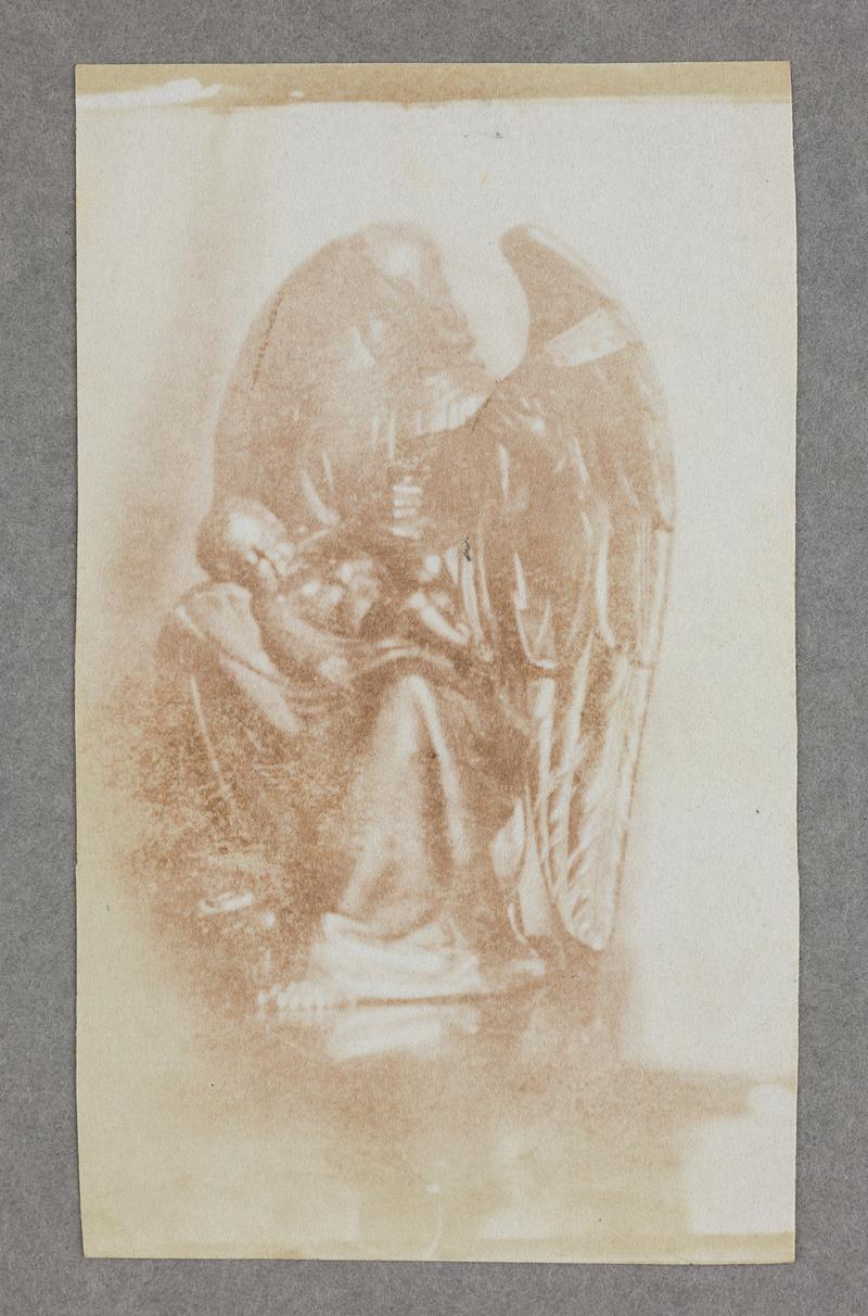 statue of an angel holding a baby, photograph