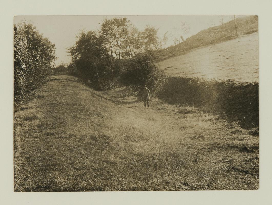 Man standing in the long abandoned bed of the Ffrwd Canal near Llay Hall and Cefn y Bedd