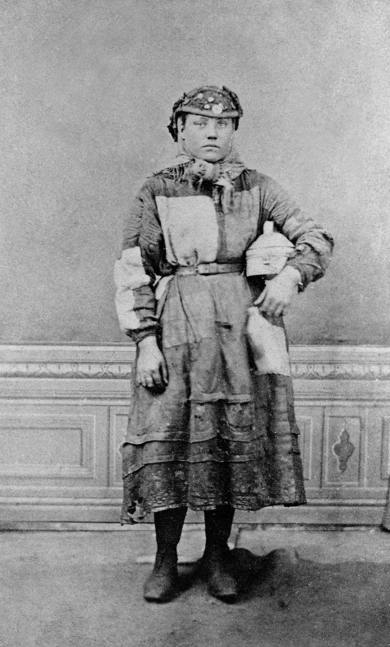 Girl employed on surface at a colliery or an ironworks, holding a food tin and &#039;water jack&#039;.