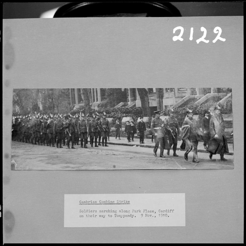 Black and white film negative of a photograph showing soldiers marching along Park Place Cardiff on their way to Tonypandy, 9 November 1910 (information taken from caption below the photograph).  &#039;1910 lockout&#039; is transcribed from original negative bag.