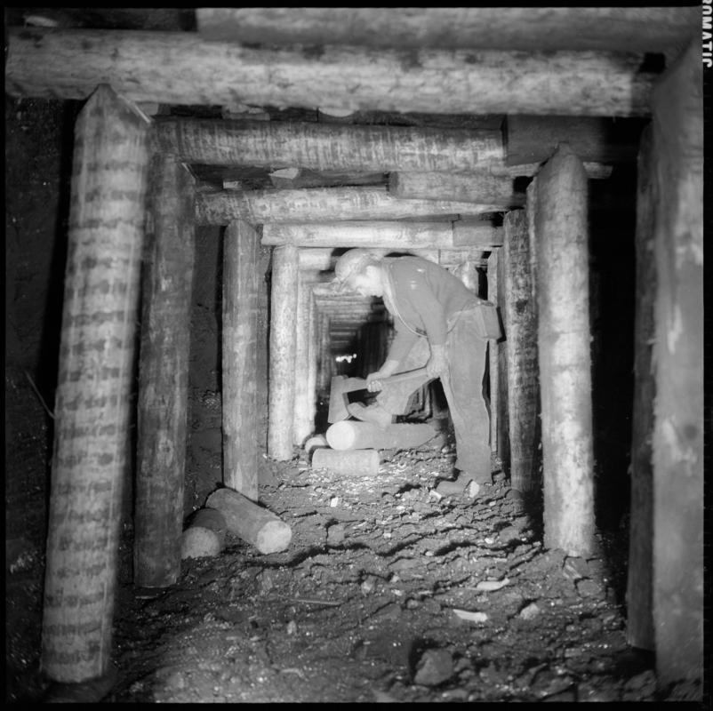 Black and white film negative showing a man preparing timber on the face, Ammanford Colliery 7 September 1976.  &#039;Ammanford 7 Sep 1976&#039; is transcribed from original negative bag.