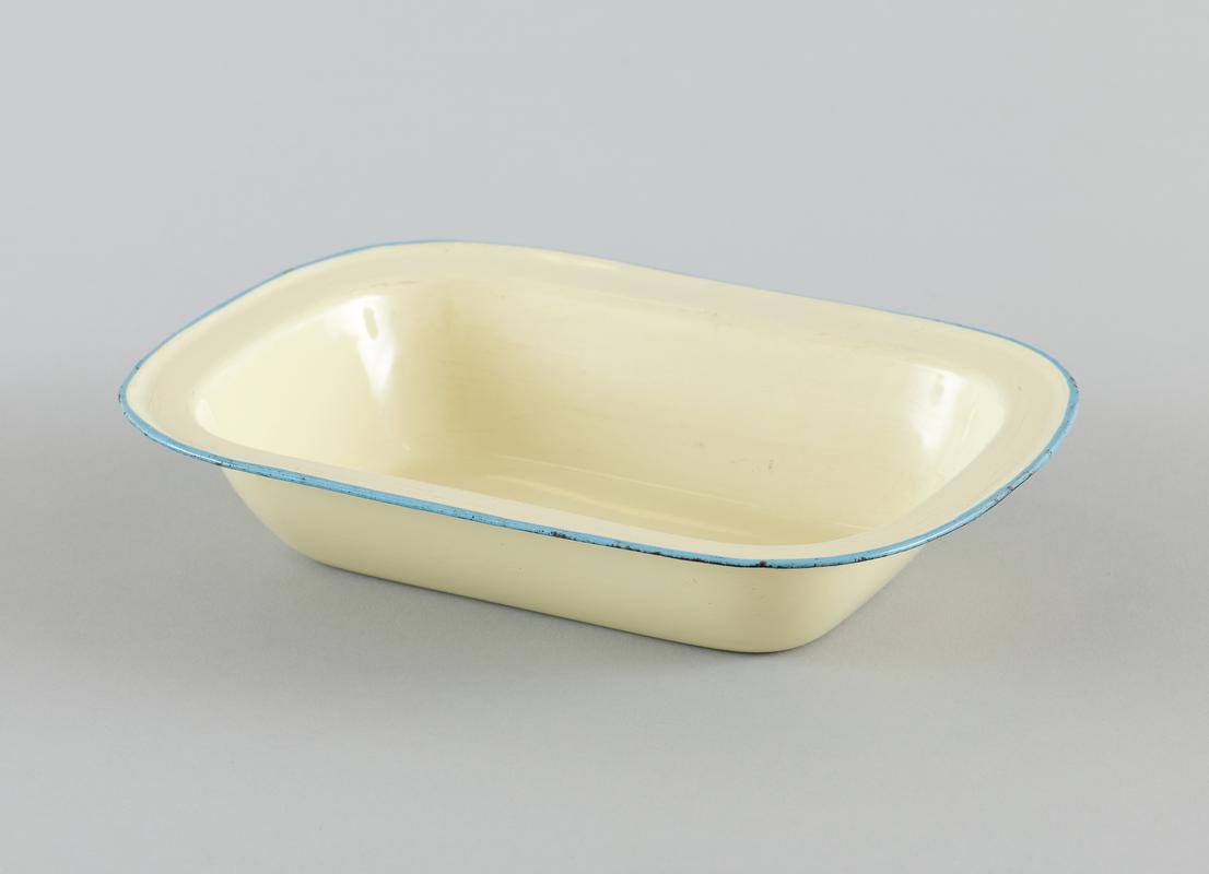 Pale yellow enamelware rectangular casserole dish with light blue rim.