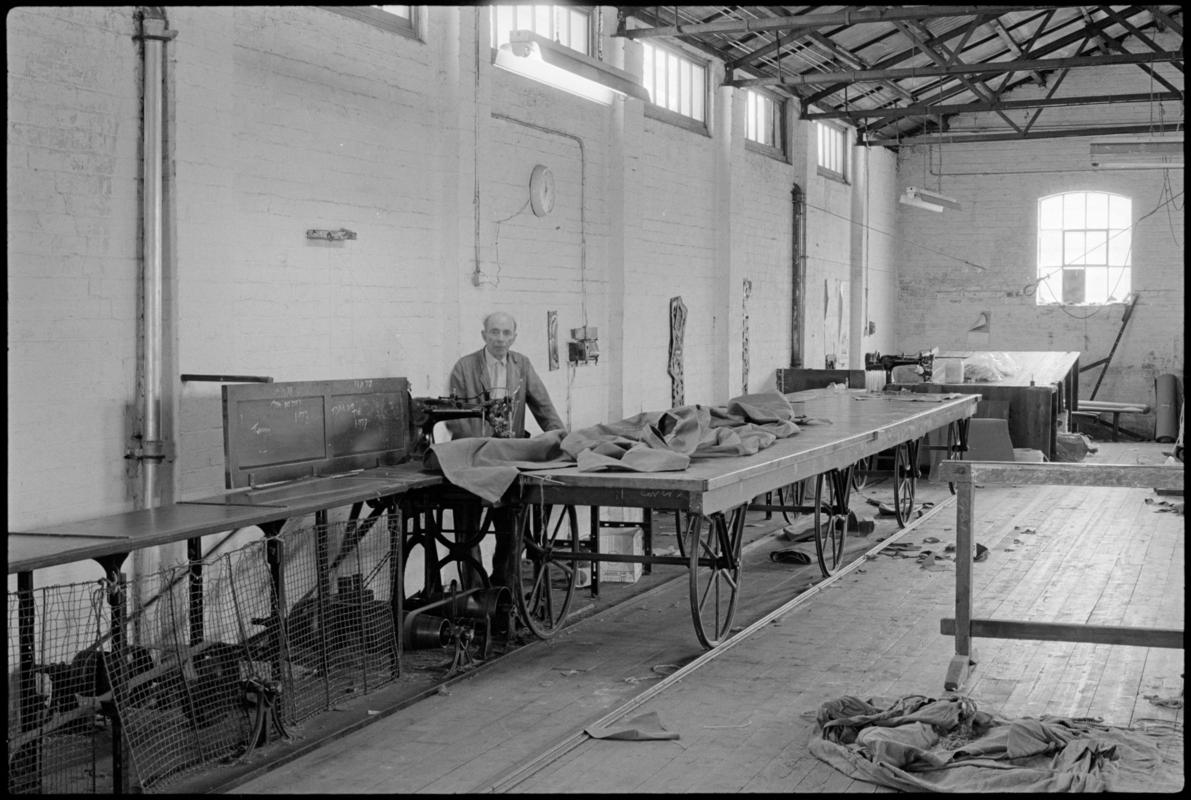 Mr Hopwood using one of the sailmaking tables with wheels that run on a track at Jenkin Jones and Son sailmakers, 12 Hurman Street, Cardiff Docks.