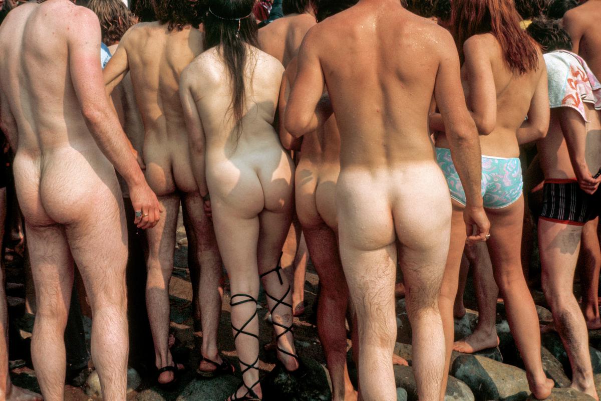 GB. ENGLAND. Isle of Wight Festival. Five assorted buttocks in a row : a girl wearing nothing but roman sandals stands in the middle. 1969.