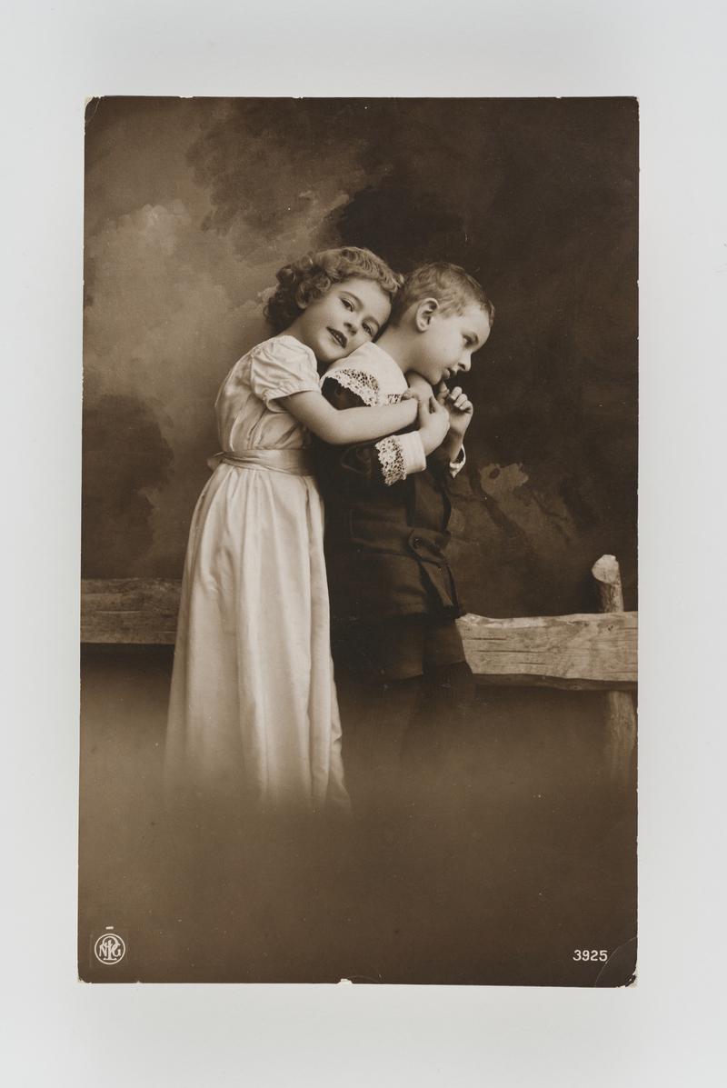 Studio photograph of a young girl and boy in affectionate pose.  Postmark: Pontypridd.