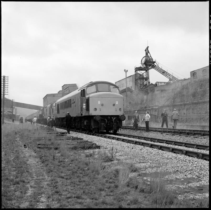 Black and white film negative showing a locomotive passing through Abertillery New Mine, 1977. &#039;1977&#039; is transcribed from original negative bag.