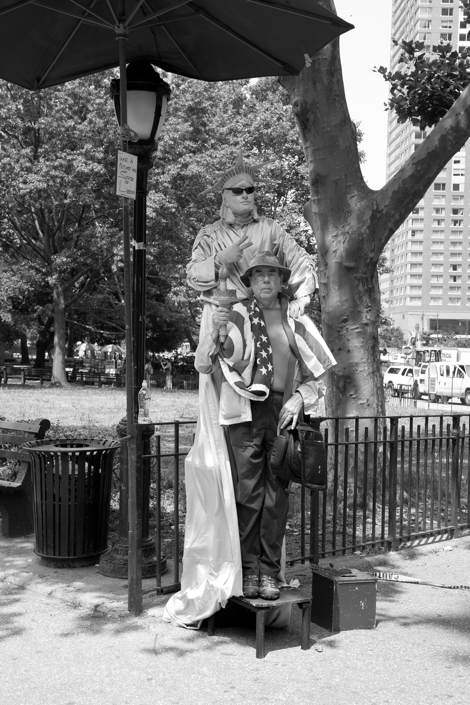Battery Park. Photographer David Hurn and the Statue of Liberty. A tourist through and through. New York USA