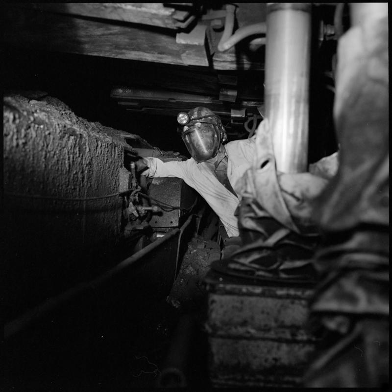 Black and white film negative showing a man at work underground, unknown colliery.