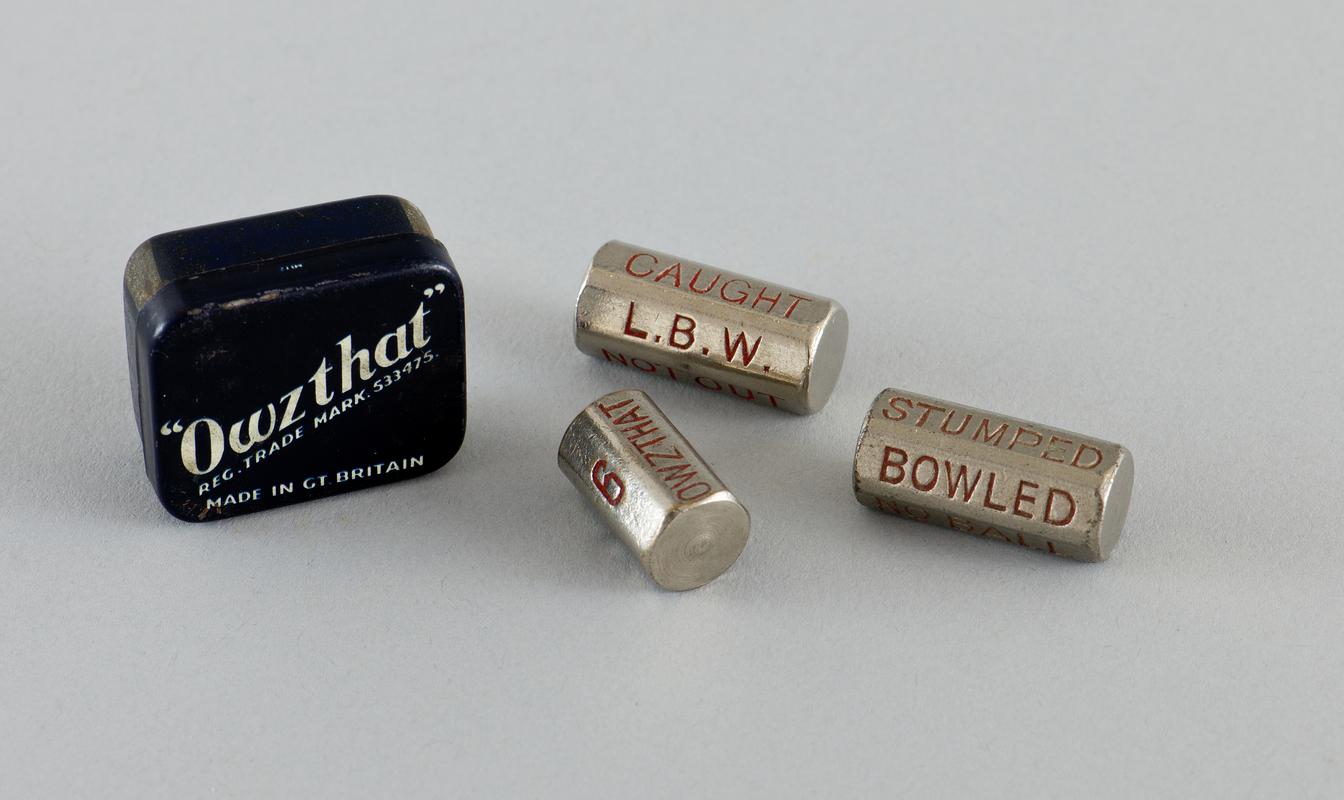 Owzthat&#039; game in original tin with spare bowling &#039;dice&#039;.  Navy blue tin has brand name diagonally across centre of lid in white and contains metal bowling &#039;dice&#039; and metal numerical runs &#039;dice&#039;.