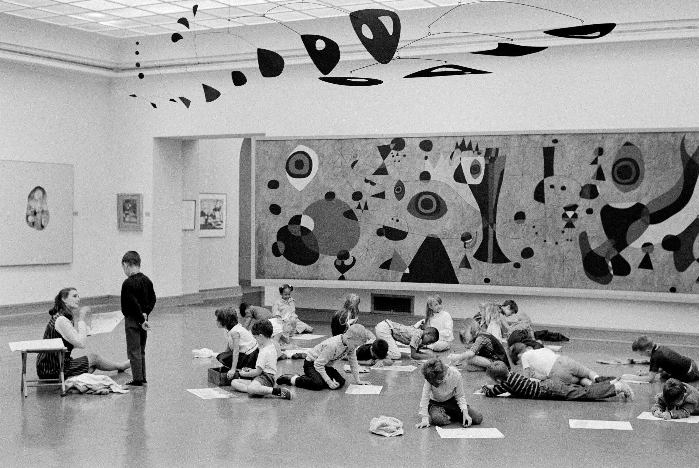 School art class in the museum. Miro painting in the background and Calder mobile overhead. Cincinnati, USA