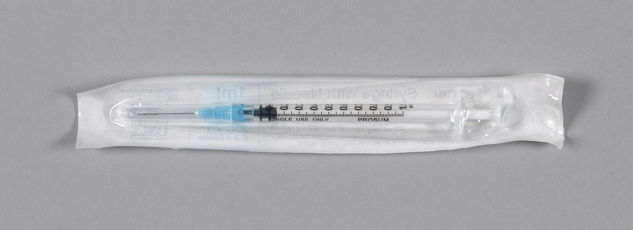 Unused syringe with needle, in sterile packing.
