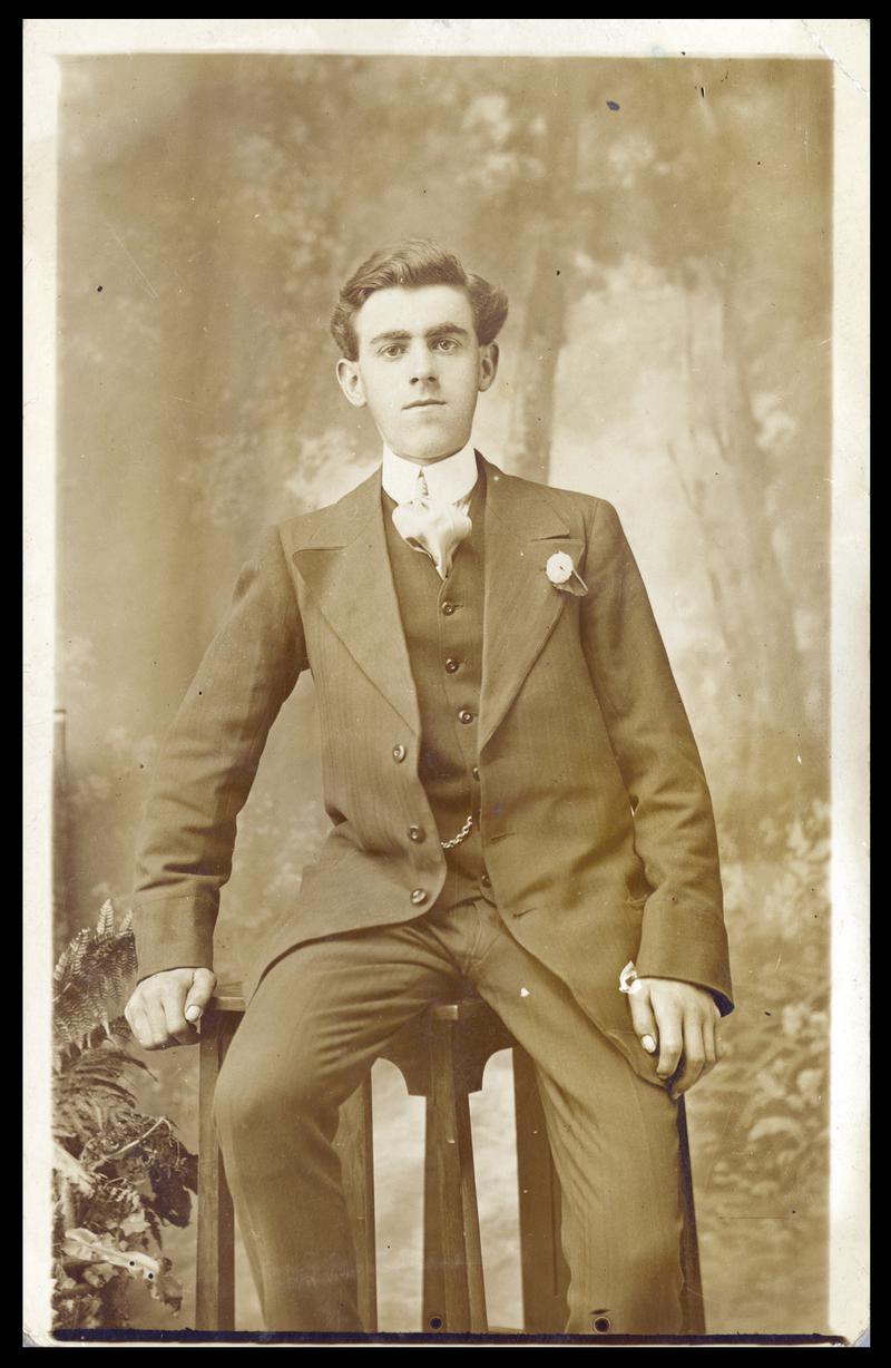 Gentleman dressed in a smart suit sitting on a stool (front &amp; Back)