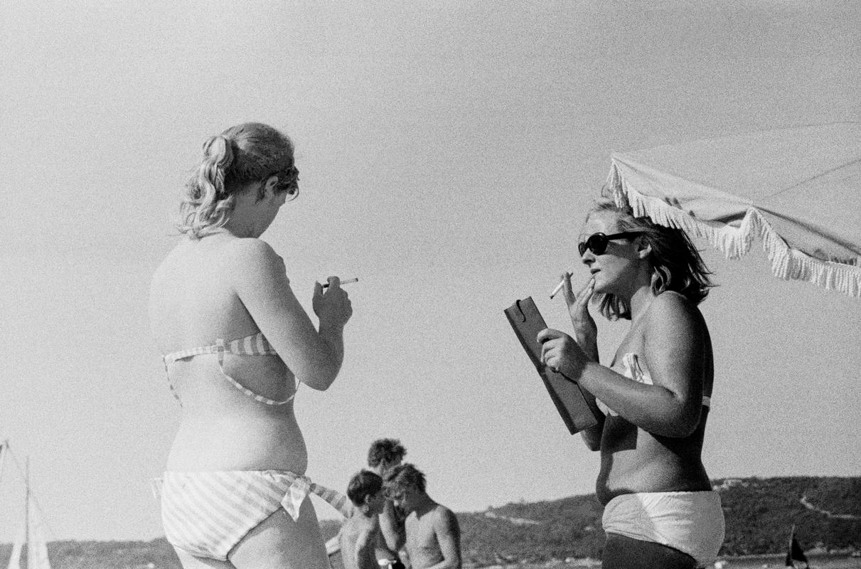 FRANCE. Saint-Tropez. Smoking on the beach. A la Carte. 1964.