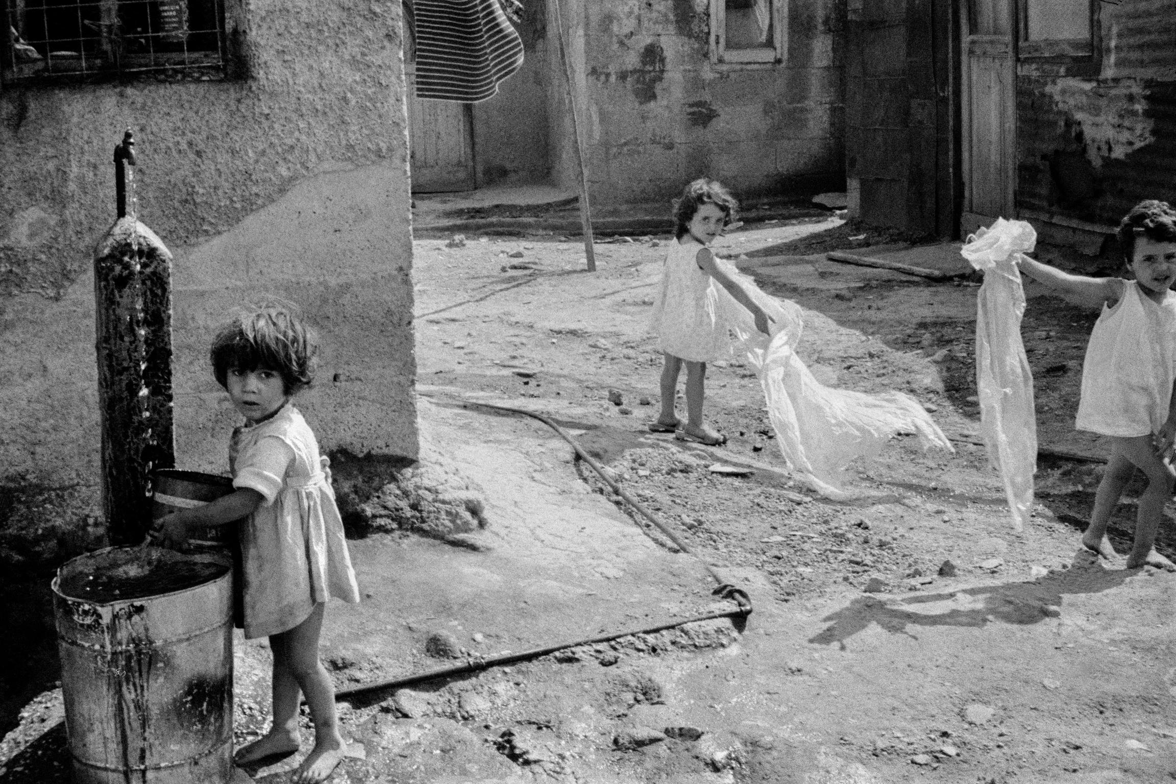 Children playing and collecting water. Ischia. Italy