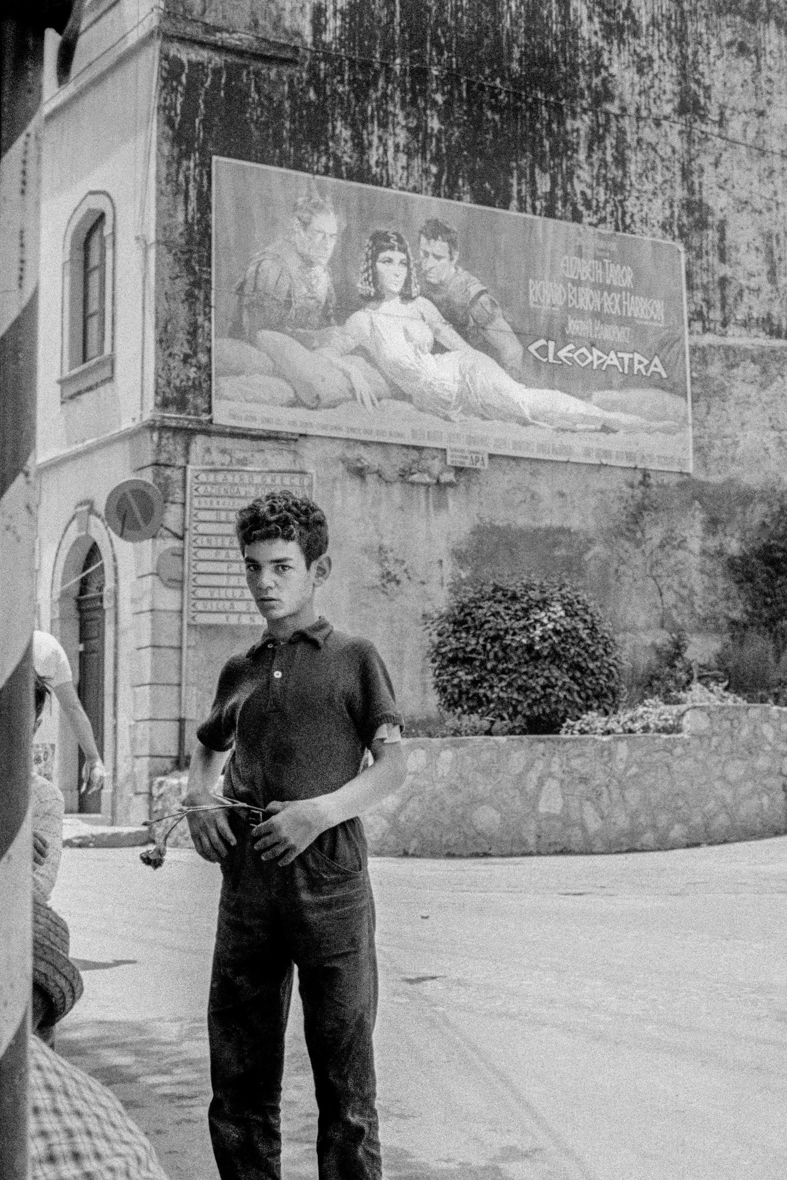 Boy and flower plus cinema poster. Taormina, Sicily. Italy
