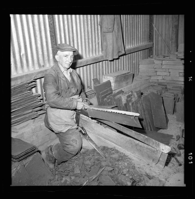 Quarryman using a measuring stick, &#039;pric mesur&#039;, to measure a piece of slate before it is dressed, Dinorwig Quarry, early 1960s.