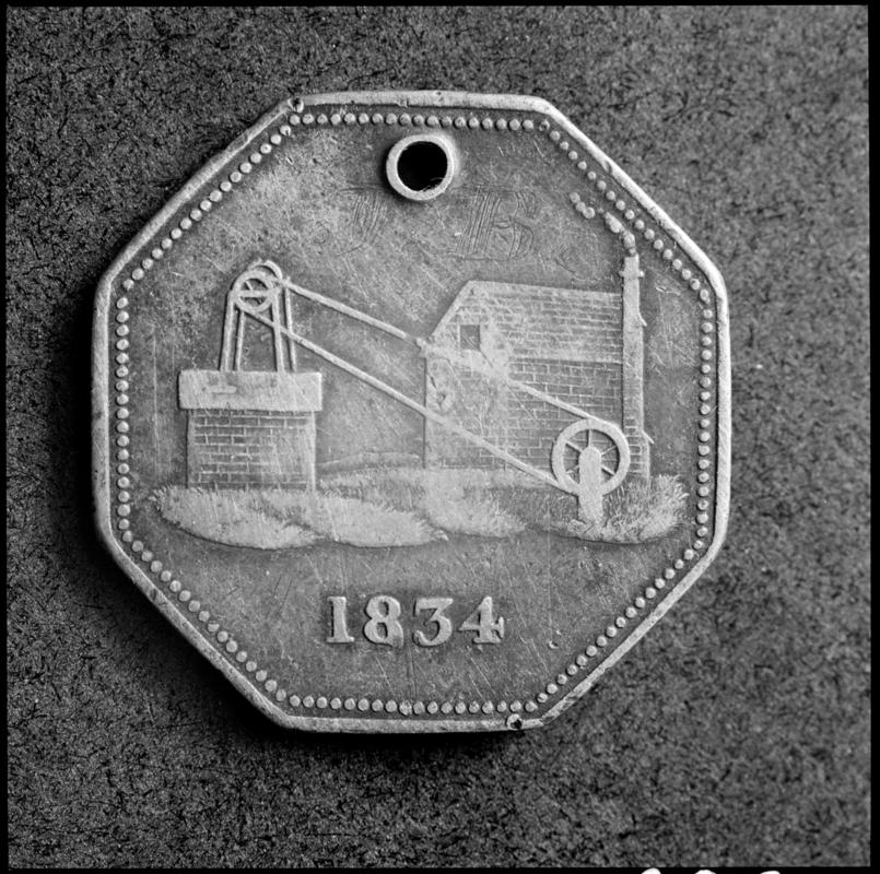 Black and white film negative showing the reverse of a colliery token, 1834.