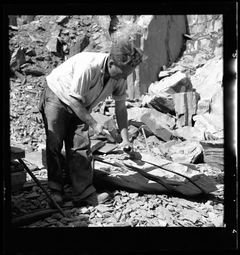 Quarryman preparing a large section of rock to be transported to the slate splitting and slate dressing sheds - &#039;bras hollti plyg&#039;,  Dinorwig Quarry, early 1960s.