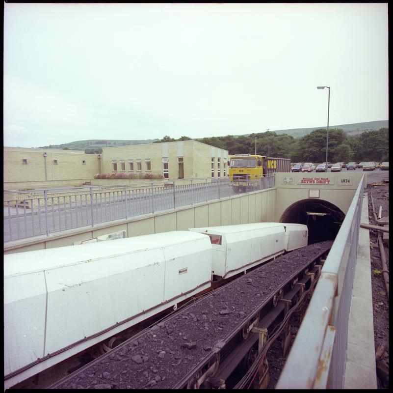 Colour film negative showing the entrance to the mine with man riding cars and conveyor, Betws Mine 10 June 1982.  &#039;10 Jun 1982&#039; is transcribed from original negative bag.  Appears to be identical to 2009.3/2178.