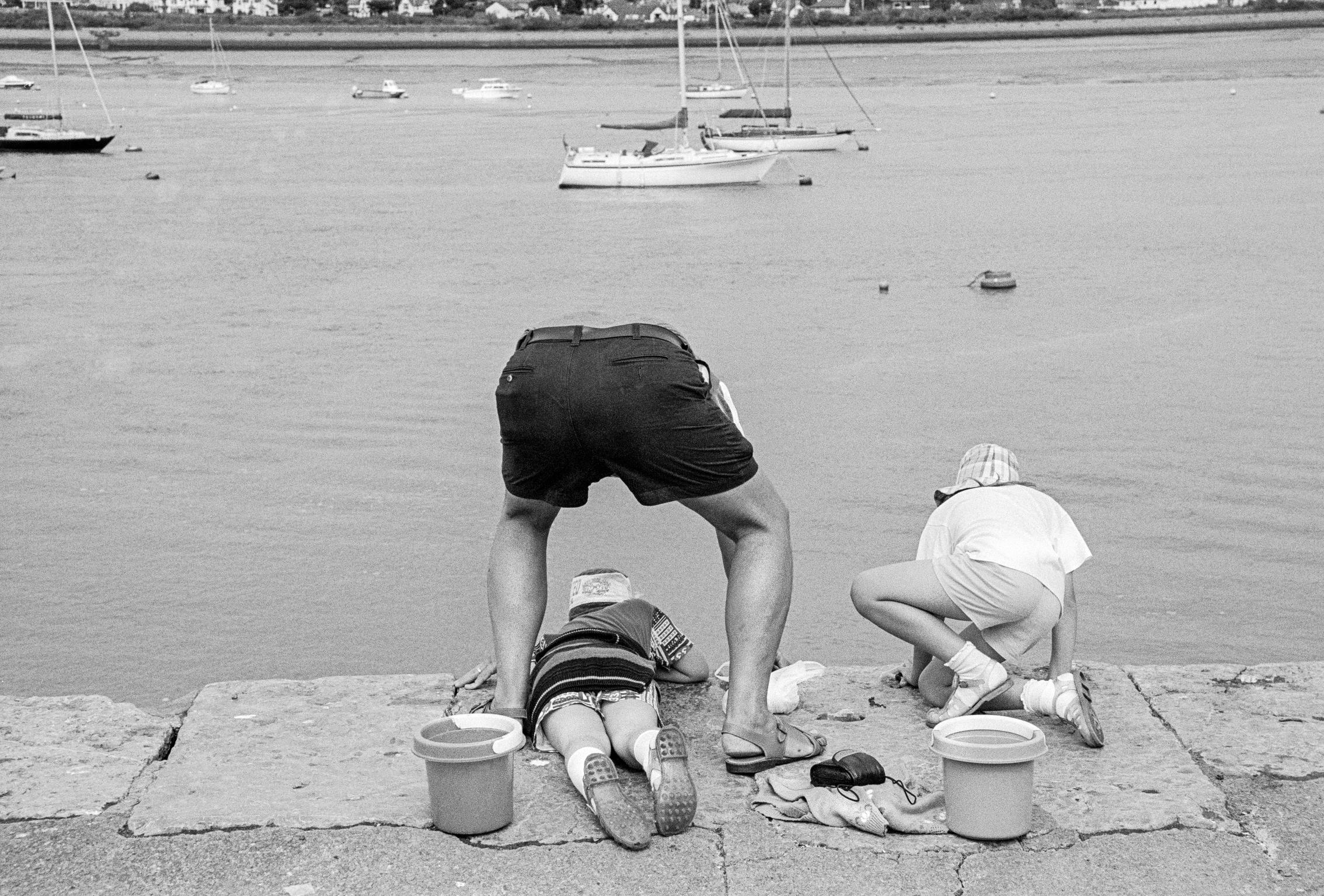 Family fishing for crabs on the front. Conway, Wales
