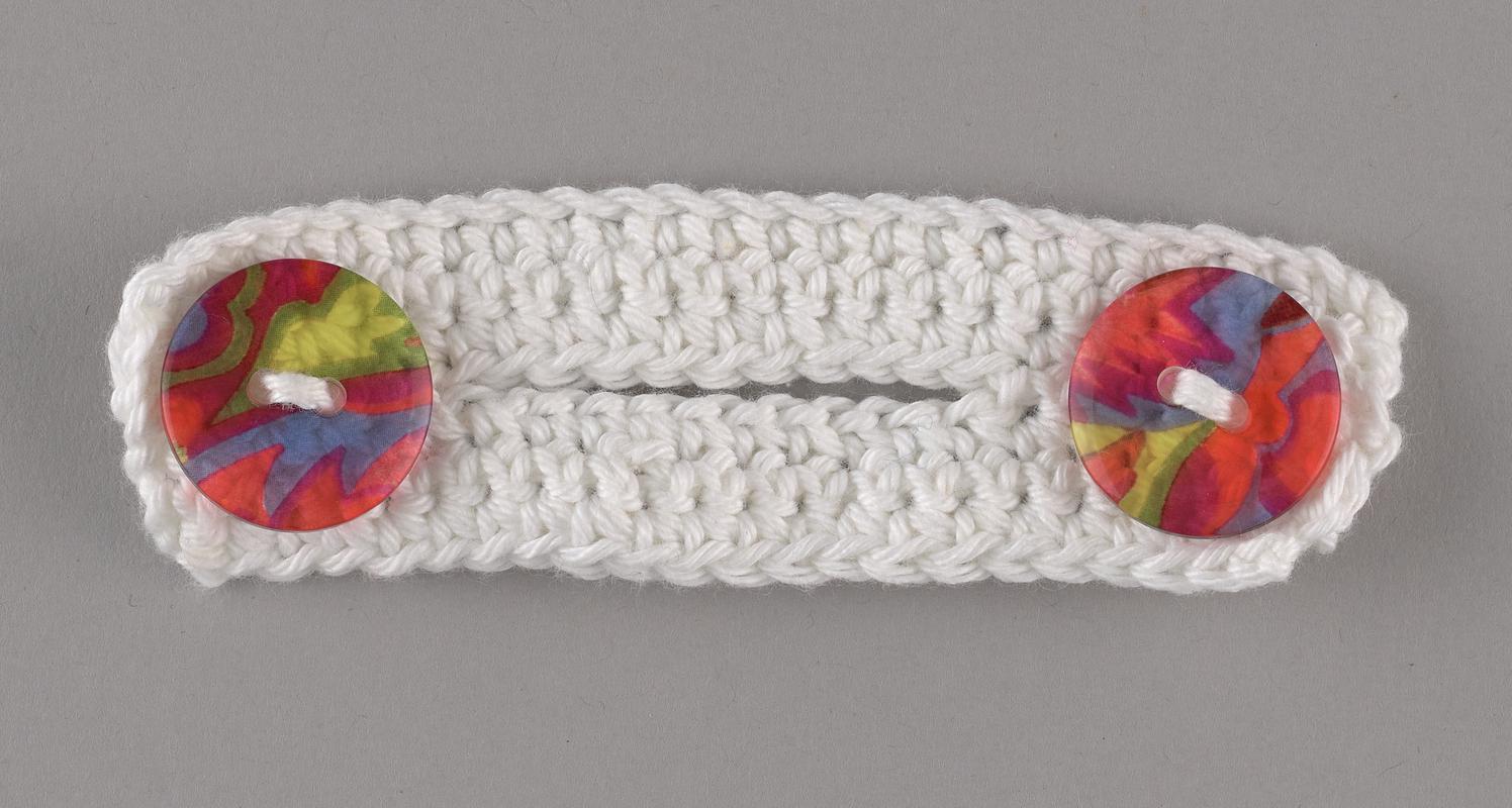 Hand-knitted ear protector/mask extender. White with multicoloured buttons.
