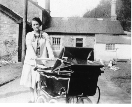 Dinorwig Quarry Hospital. Marie Therese Hughes and Vivian Hughes (in pram) outside DQH - side view of the hospital
