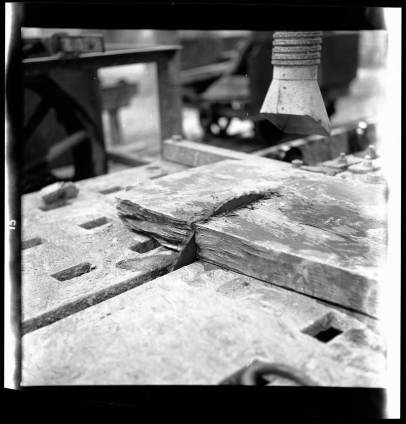 Slate slab being sawn on a saw table, showing dust extraction system above blade.