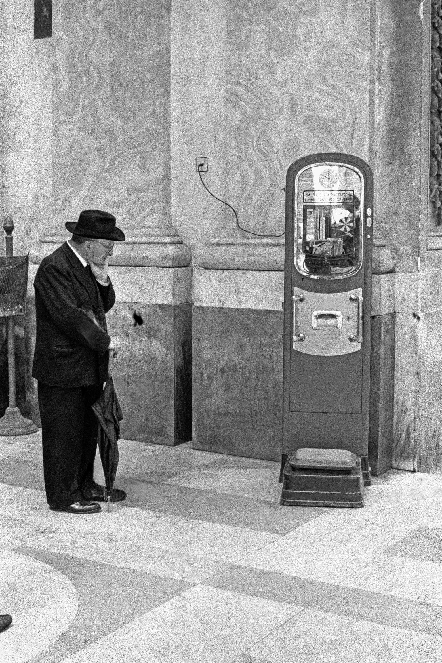 Weighing machine plus thoughtful observer. Naples. Italy
