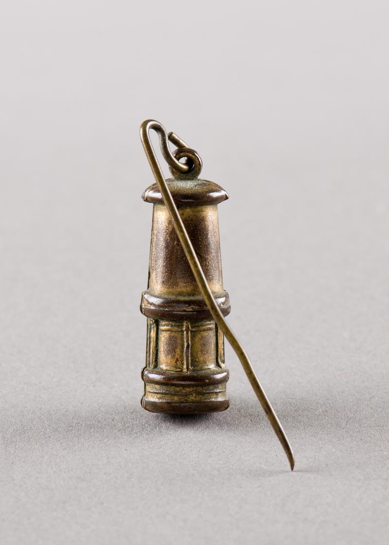 Pin badge in the shape of a miners lamp. Sold for funds during the 1926 strike (Rhondda).